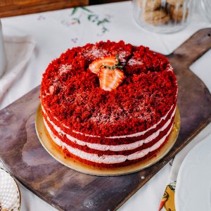 Top-down shot of a red velvet cake on a wooden board.