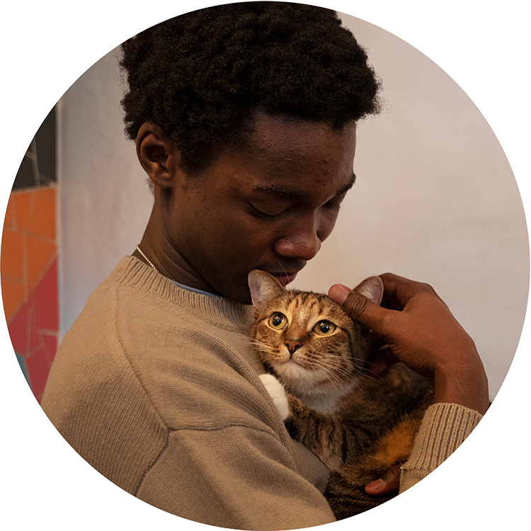 Black man holding his orange cat in his arms