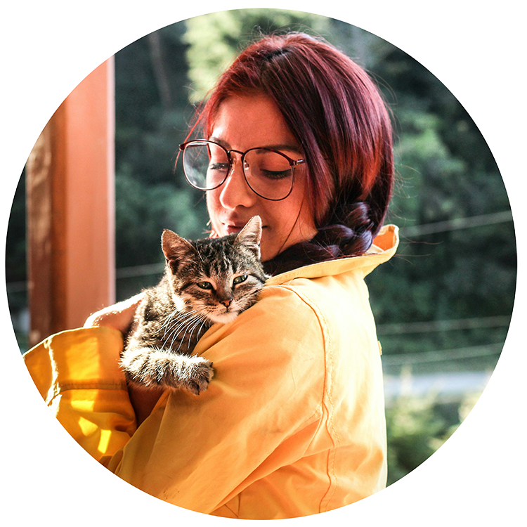 Red-haired woman holding her tabby cat in her arms