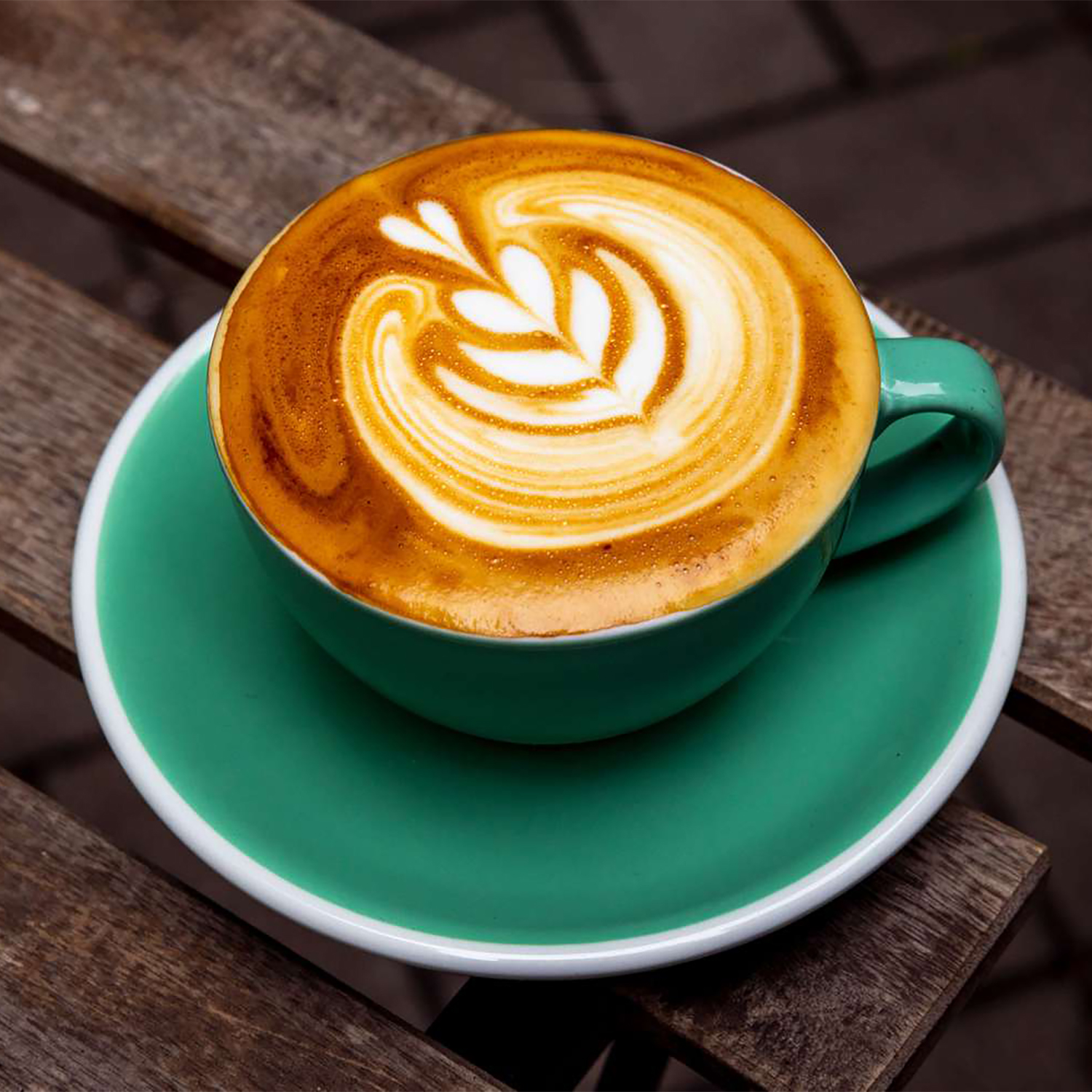 Closeup on a flat white in a teal ceramic cup